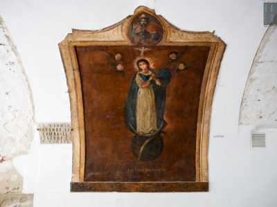 L�iconografia qui � completa. C�� Dio posto in alto, lo Spirito Santo rappresentato dalla colomba e Ges� ancora nel grembo materno. La Vergine con le mani giunte � circondata da angeli e ai suoi piedi ci sono la falce di luna e un serpente schiacciato, simbolo della vittoria sul male